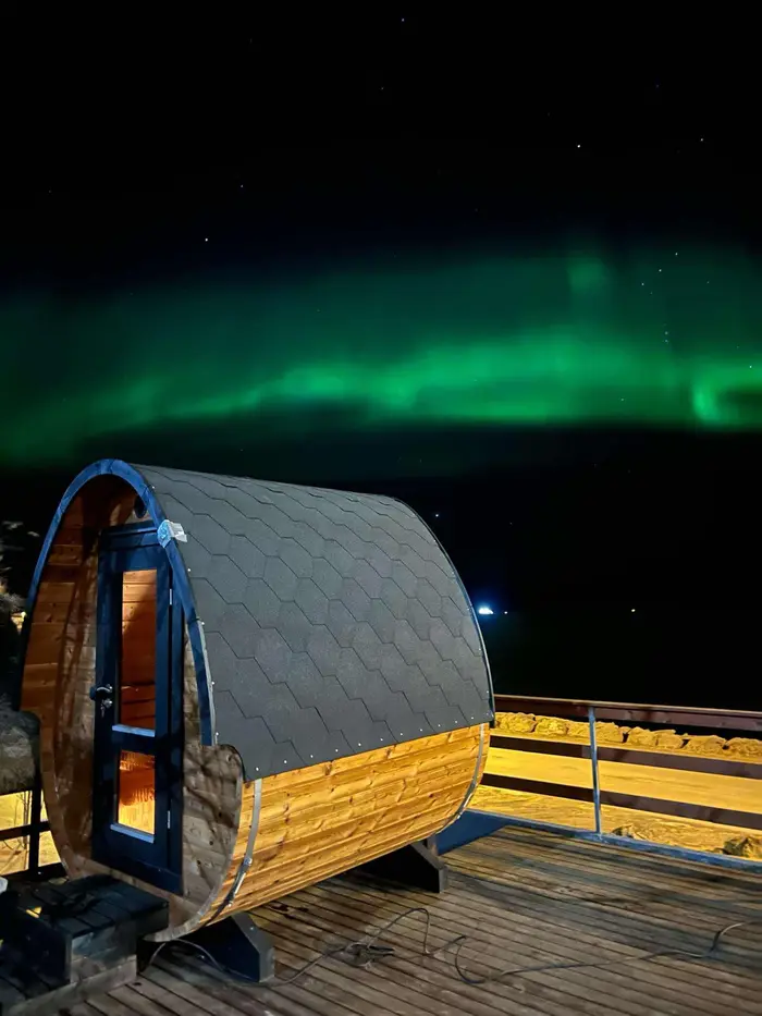The barrel sauna on the deck under the northern lights