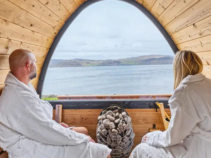 Two guests in the sauna looking out over the fjord