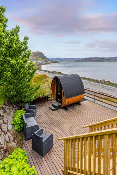 Outdoor deck with barrel sauna overlooking the fjord at Hotel West